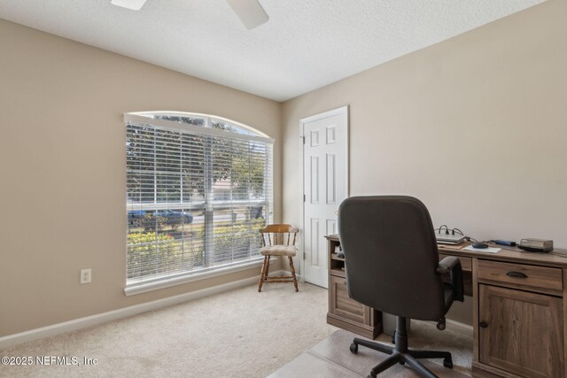 home office with ceiling fan, light colored carpet, baseboards, and a textured ceiling