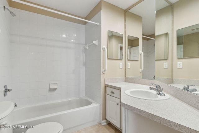 bathroom featuring tile patterned floors, toilet, vanity, and  shower combination