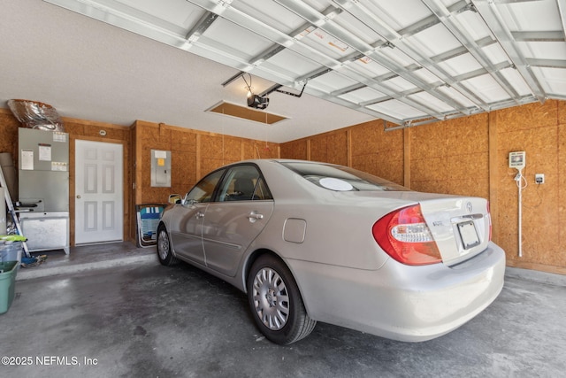 garage with electric panel and a garage door opener