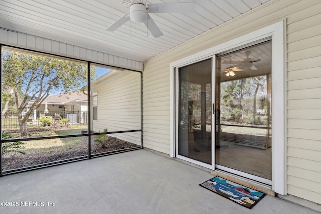 unfurnished sunroom featuring a ceiling fan