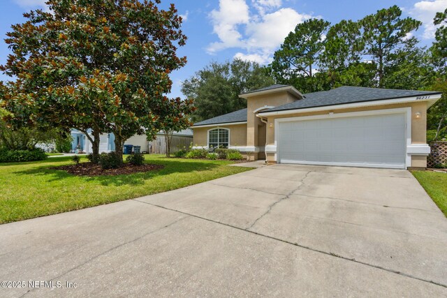 96231 Abaco Island Dr, Fernandina Beach, FL 32034 - view of front of home featuring stucco siding, concrete driveway, an attached garage, a front yard, and a shingled roof