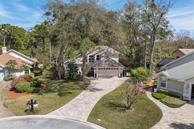 view of front of house featuring a front yard, decorative driveway, an attached garage, and stucco siding