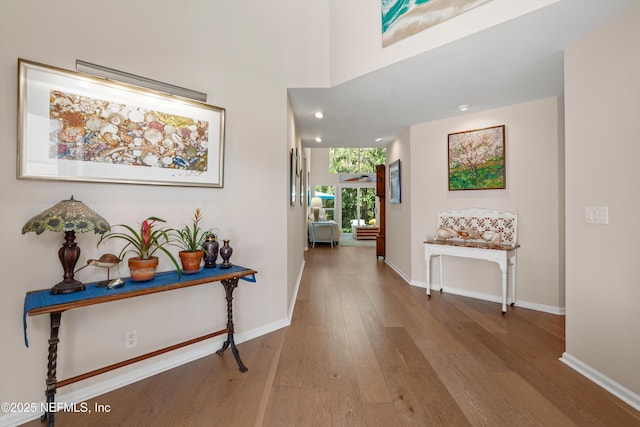 hallway with baseboards and hardwood / wood-style floors