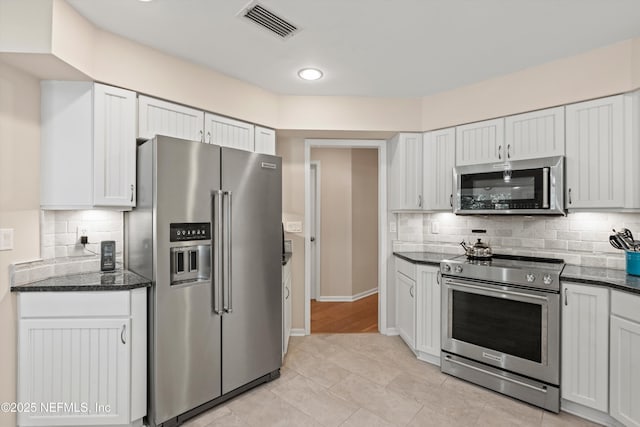 kitchen with baseboards, visible vents, appliances with stainless steel finishes, white cabinetry, and tasteful backsplash