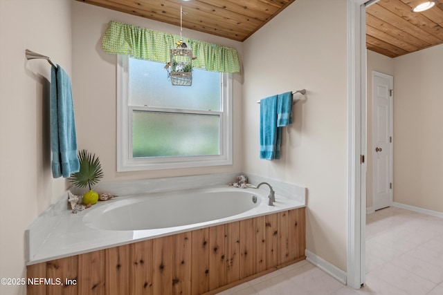 bathroom with baseboards, wood ceiling, and a bath