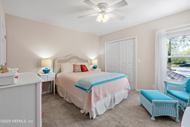 bedroom featuring a ceiling fan, baseboards, a closet, and light carpet