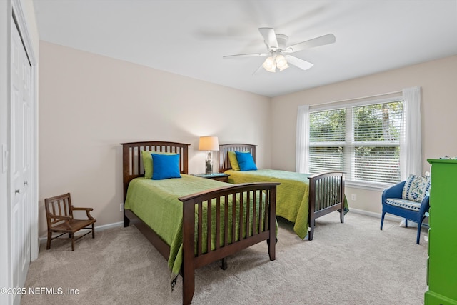 bedroom with a ceiling fan, light colored carpet, and baseboards