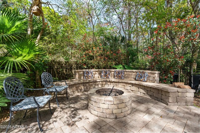 view of patio featuring fence and an outdoor fire pit