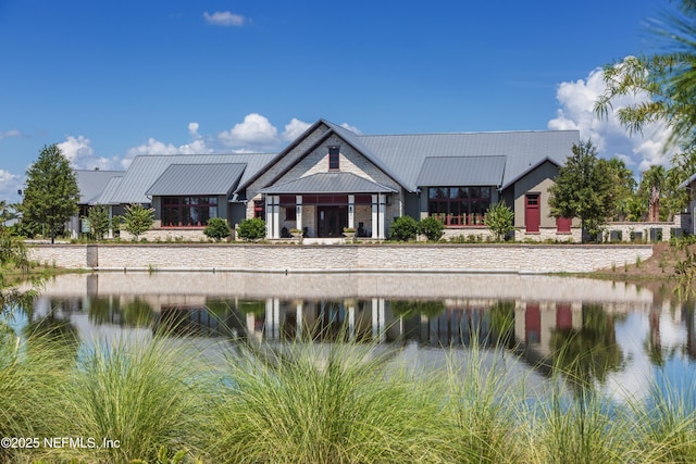 exterior space featuring metal roof, a standing seam roof, and a water view