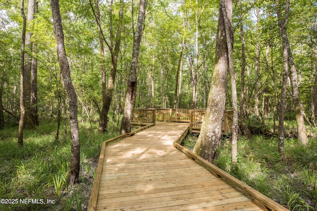 view of home's community with a deck and a view of trees