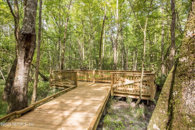 surrounding community featuring a deck and a wooded view