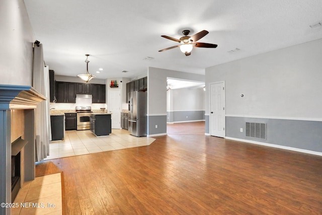 1601 Majestic View Ln, Fleming Island, FL 32003 - unfurnished living room with a ceiling fan, light wood finished floors, and a tile fireplace
