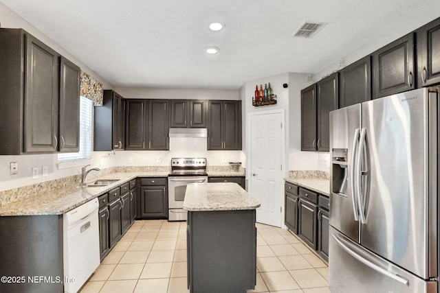 1601 Majestic View Ln, Fleming Island, FL 32003 - kitchen with stainless steel appliances, under cabinet range hood, a kitchen island, light stone countertops, and recessed lighting