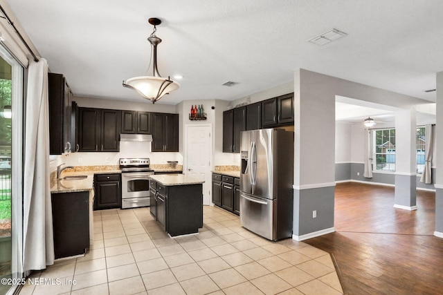 1601 Majestic View Ln, Fleming Island, FL 32003 - kitchen featuring stainless steel appliances, under cabinet range hood, ceiling fan, a center island, and light stone counters