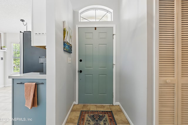 entryway with light tile patterned floors and baseboards