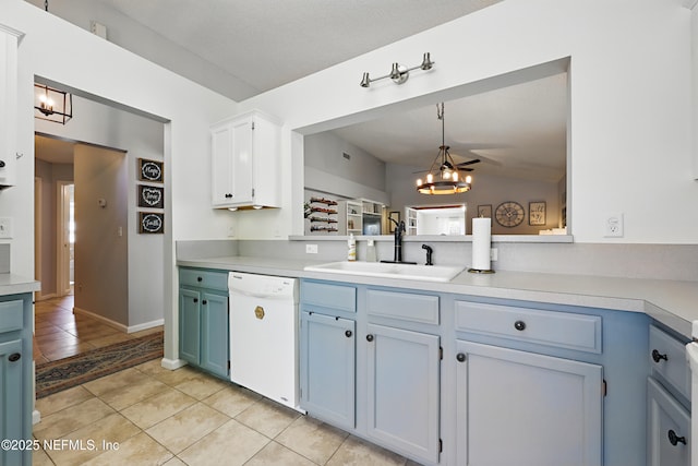 kitchen with light tile patterned floors, a sink, light countertops, dishwasher, and a notable chandelier