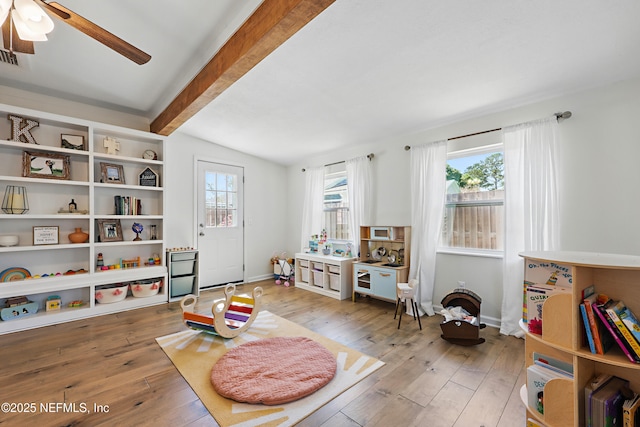 game room with baseboards, plenty of natural light, light wood-style floors, and vaulted ceiling with beams