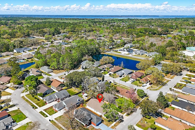 drone / aerial view featuring a residential view, a forest view, and a water view