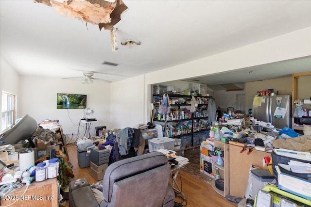 interior space featuring ceiling fan, visible vents, and wood finished floors