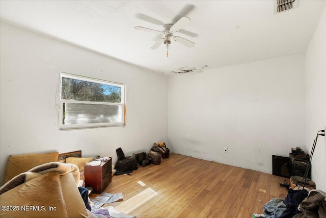 interior space with wood finished floors, visible vents, and ceiling fan