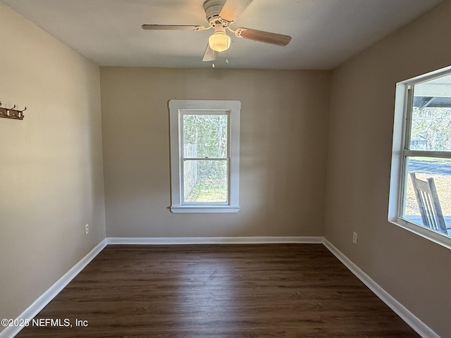 unfurnished room with baseboards, a ceiling fan, and dark wood-style flooring