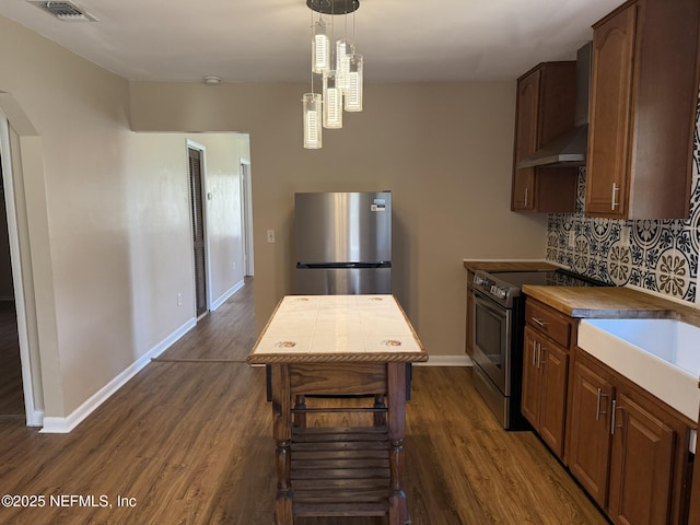 kitchen featuring visible vents, backsplash, dark wood-type flooring, appliances with stainless steel finishes, and wall chimney exhaust hood