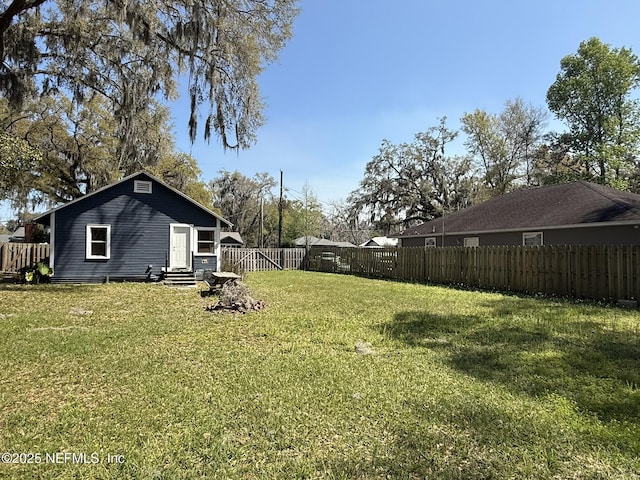 view of yard with a fenced backyard and entry steps