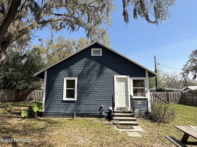 view of front of home featuring a front lawn and fence