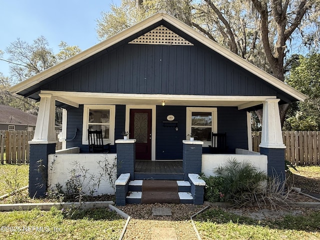 view of front of property featuring covered porch and fence