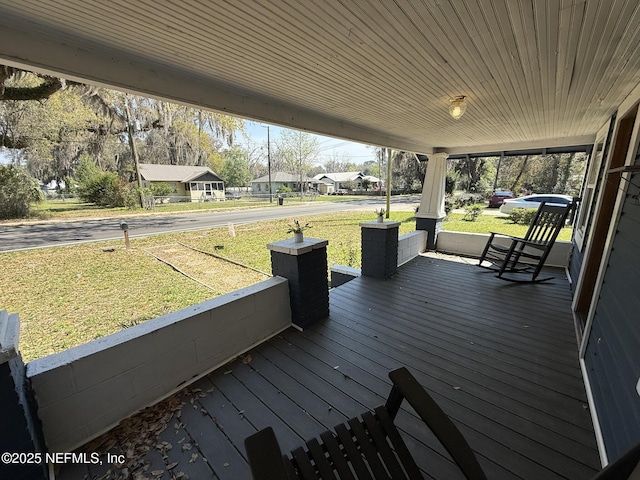 wooden terrace with a yard and covered porch