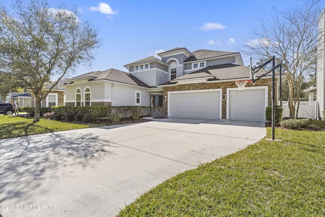 view of front of property featuring a front lawn, fence, stucco siding, stone siding, and an attached garage