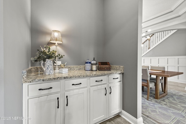 bar featuring light wood-style flooring and baseboards