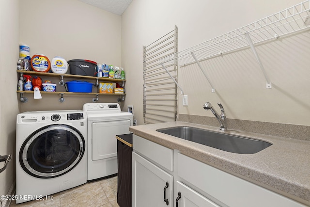 washroom featuring washer and clothes dryer, cabinet space, and a sink