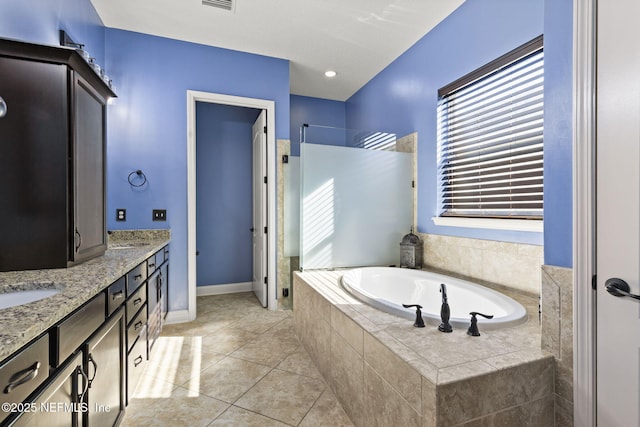 full bath with tile patterned floors, a garden tub, a sink, double vanity, and walk in shower