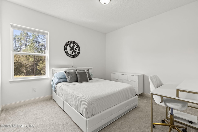 bedroom with a textured ceiling, baseboards, and carpet floors