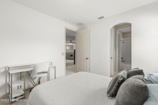 carpeted bedroom with arched walkways, visible vents, a textured ceiling, and baseboards