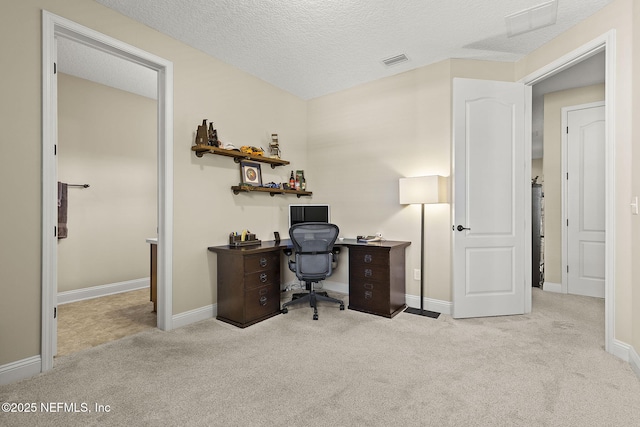 carpeted office with visible vents, a textured ceiling, and baseboards