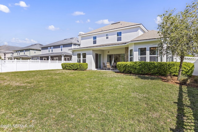 rear view of property with a yard, a patio, stucco siding, and fence