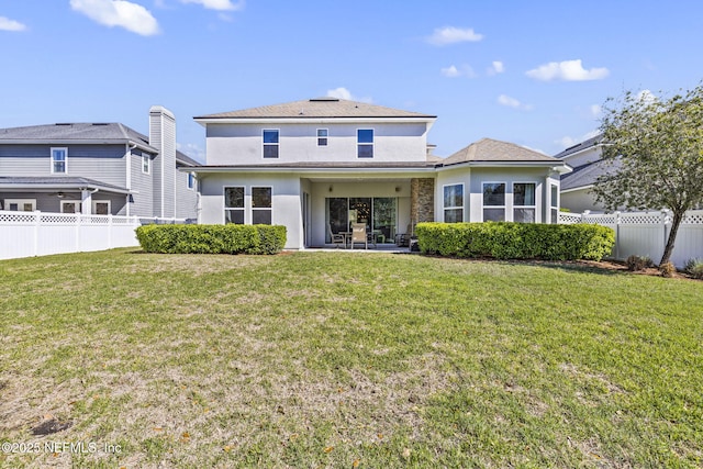 rear view of property featuring a patio area, fence private yard, and a yard