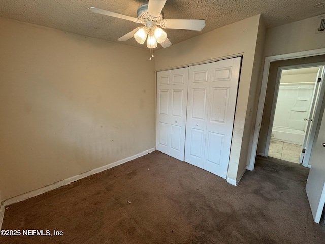 unfurnished bedroom featuring a closet, a textured ceiling, and dark carpet