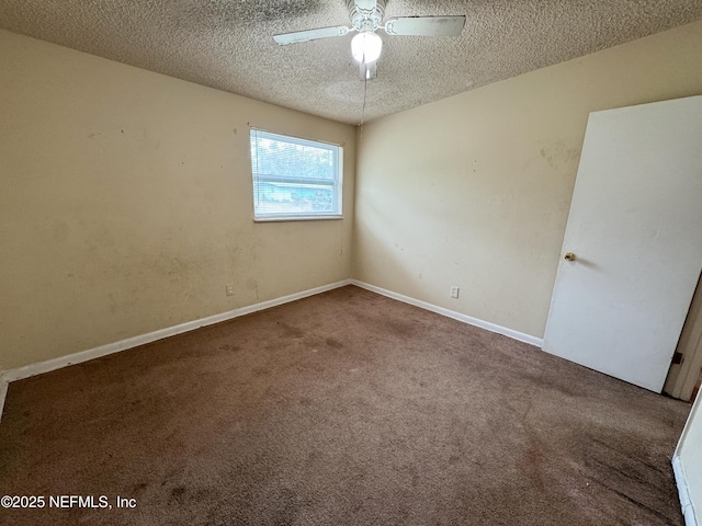 carpeted spare room featuring a textured ceiling, baseboards, and a ceiling fan