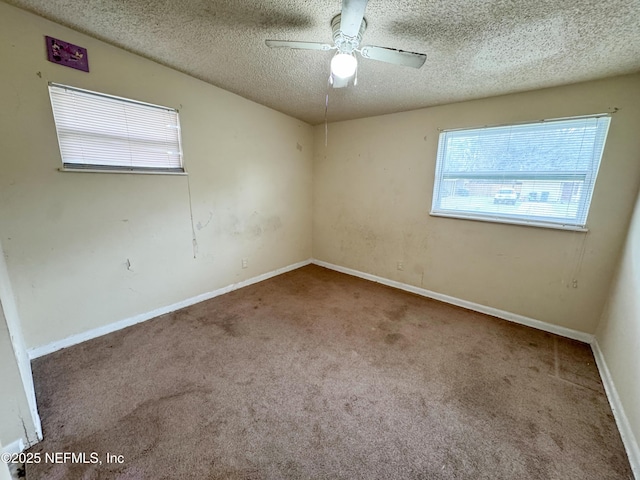 empty room featuring baseboards, ceiling fan, a textured ceiling, and carpet