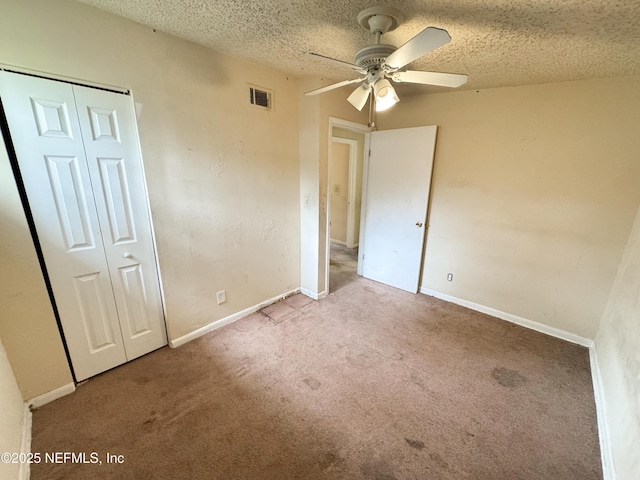 unfurnished bedroom with baseboards, visible vents, carpet floors, a closet, and a textured ceiling