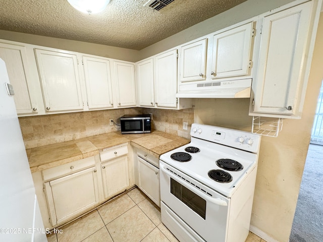 kitchen featuring electric range, under cabinet range hood, a textured ceiling, stainless steel microwave, and backsplash