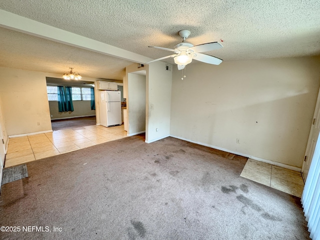 carpeted spare room with baseboards, visible vents, a textured ceiling, tile patterned floors, and ceiling fan with notable chandelier