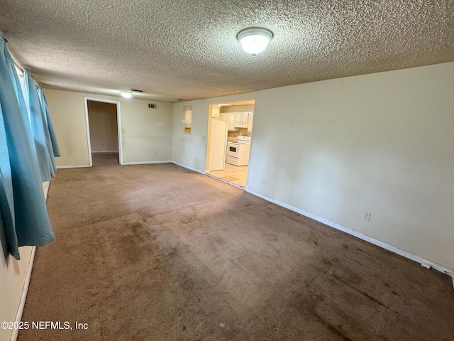 unfurnished room with visible vents, baseboards, carpet, and a textured ceiling