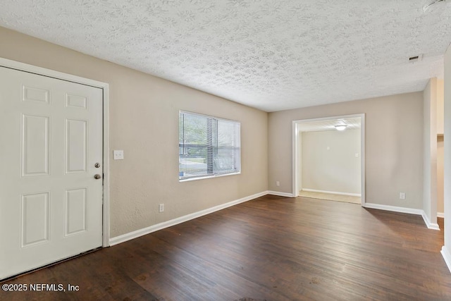 entrance foyer with a textured ceiling, baseboards, and wood finished floors