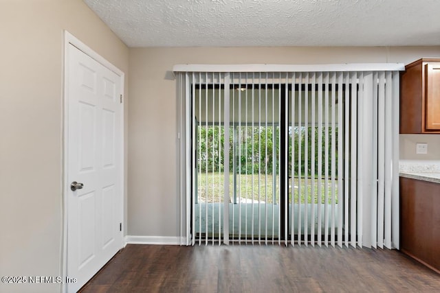 interior space with wood finished floors, baseboards, and a textured ceiling