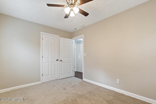 unfurnished bedroom with a ceiling fan, a textured ceiling, a closet, carpet floors, and baseboards