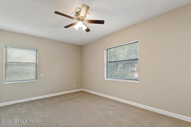 carpeted empty room with baseboards and a ceiling fan